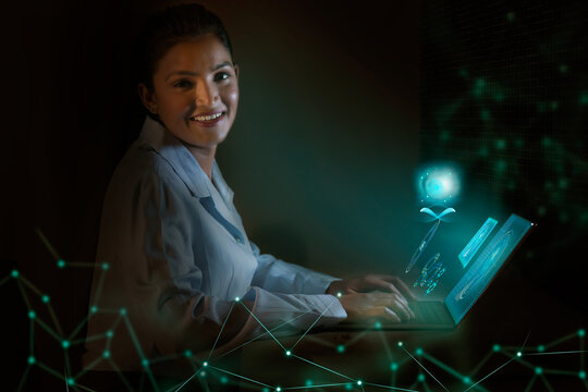 Businesswoman working on laptop computer with icons on virtual screen