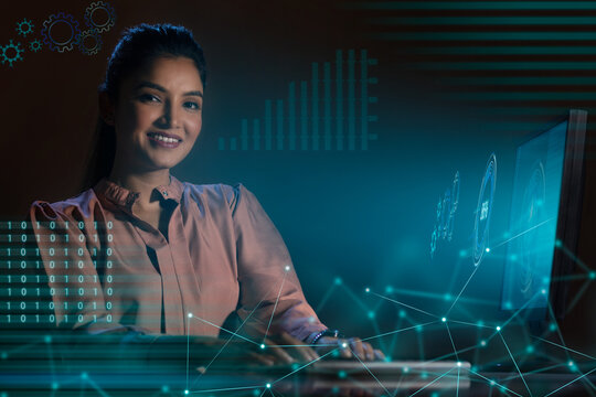 Businesswoman working on laptop computer with icons on virtual screen