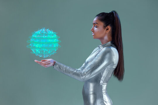 A model dressed in a  silver robotic suit or a  futuristic robotic dress holding a digital globe