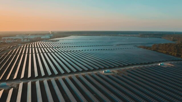A large number of solar panels at sunset drone view.
