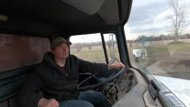 Man inside 1972 dump truck driving into construction site
