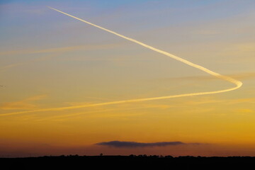 Sunset sky with plane vapour trail