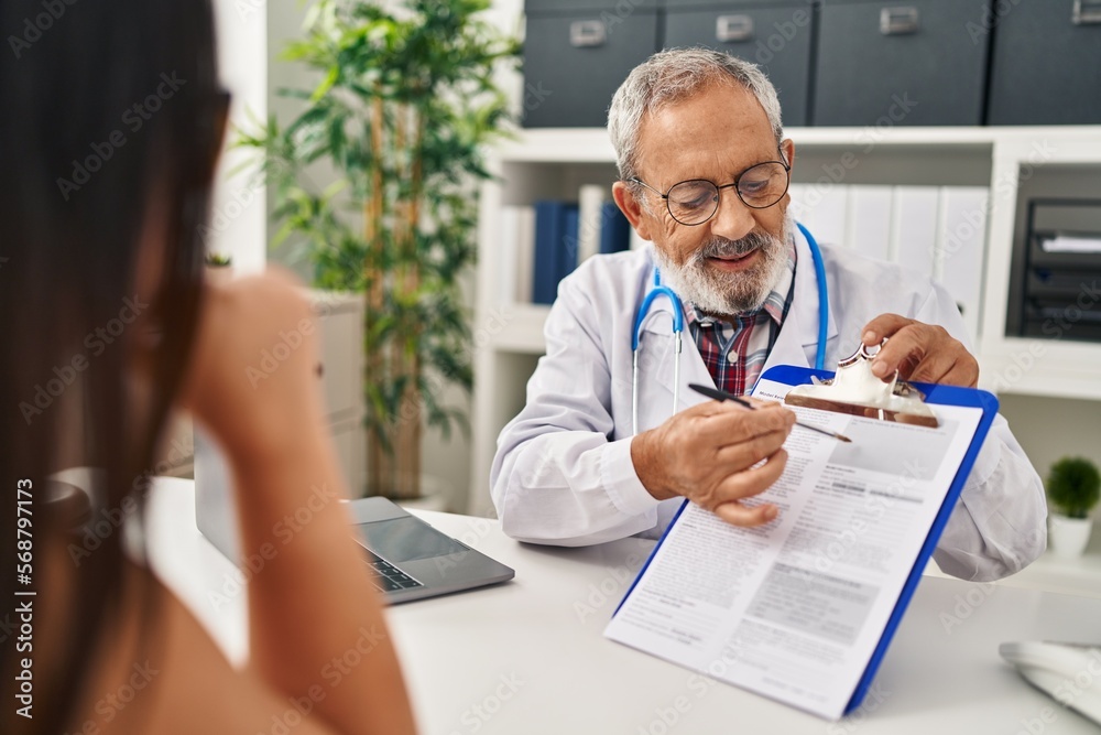 Poster Senior grey-haired man doctor and patient having medical consultation at clinic