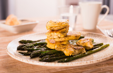 fried chicken breast pieces with asparagus on white plate