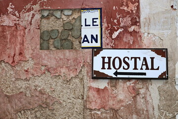 Spanish wall with missing sign tiles and Hostal sign