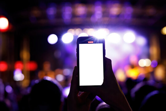 Using a mobile phone at a music concert. Mock-up with a blank screen for your picture.