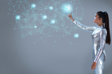 A woman wearing silver futuristic clothes touching a virtual icons on a virtual Screen