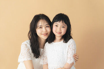 寄り添う女性と女の子　親子の美容イメージ