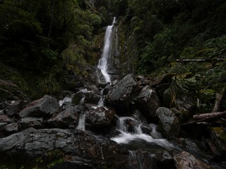 Avalanche creek waterfall long exposure, idyllic river cascade in green nature at Arthurs Pass Canterbury New Zealand