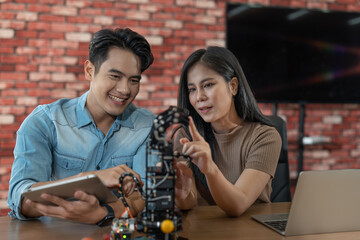Young male and female student engineer learning programming control finger arm robot. Researcher...