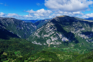 Fototapeta premium Mountain village. Summer sunny day, blue sky, mountain peaks.