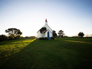 Old historic 19th century white presbyterian Awhitu Central Church with green grass, Manukau Heads Auckland New Zealand