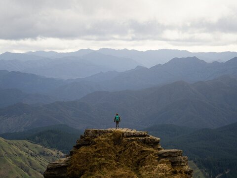 Lone hiker enjoying backcountry nature landscape mountain panorama at Bell Rock lookout in Tutira Hawkes Bay New Zealand