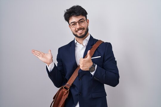 Hispanic man with beard wearing business clothes showing palm hand and doing ok gesture with thumbs up, smiling happy and cheerful
