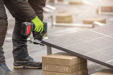 The solar panel installer twists the modules together using aluminum fasteners and a cordless...