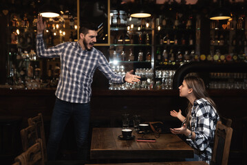 Young waiter resigns and leaves his job in a bar because of an argument with the manager due to a low salary and a lot of responsibilities at work
