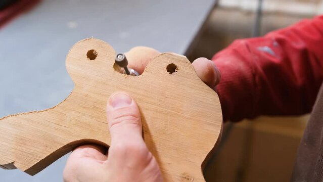 Close-up of the master's hands using powerful woodworking tools, more serious, carving during creativity, creating handmade souvenirs