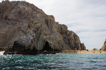 Fototapeta na wymiar Beach next to a rock formation from the sea