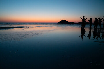 Fototapeta premium 夕暮れの浜辺 若者たちのシルエット