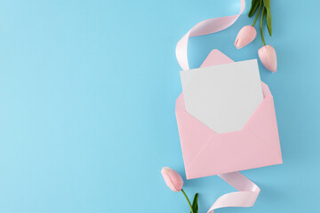 Spring holiday concept. Flat lay composition made of envelope with letter, spring flowers and ribbon on blue background. Holiday invitation card idea.
