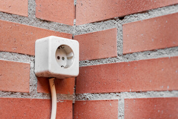 Balcony outdoor electrical outlet on a brick wall
