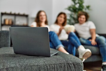 Mother and couple watching movie sitting on sofa at home