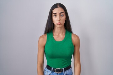 Young woman standing over isolated background depressed and worry for distress, crying angry and...