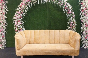 flower decoration on green grass wall with sofa in Banquet hall