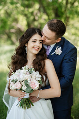 the groom and the bride are walking in the forest