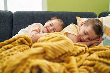 Two kids lying on sofa sleeping at home