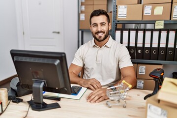 Handsome hispanic man working at small business commerce with a happy and cool smile on face. lucky person.