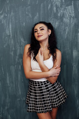 a woman in a plaid skirt in a schoolgirl costume poses