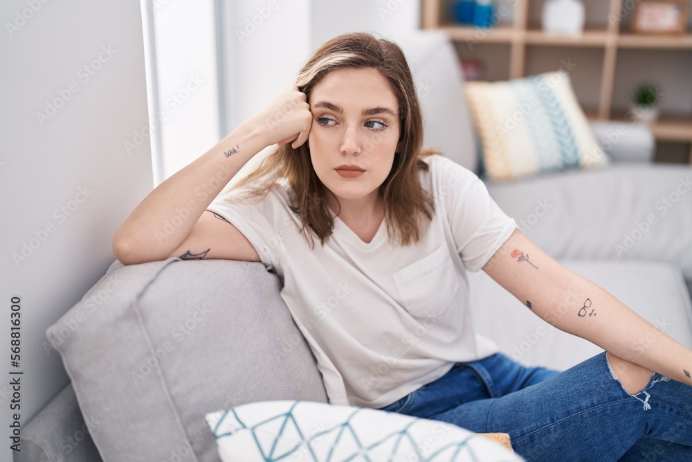 Sticker Young woman stressed sitting on sofa at home