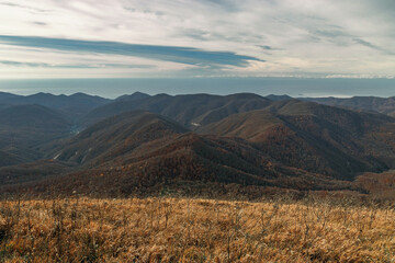 View from a great height in a picturesque place of the Caucasus. The mountain range of the Caucasus against the background of clouds. Beautiful mountain landscape. Mountain pass, mountain range. 