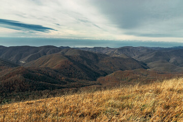 View from a great height in a picturesque place of the Caucasus. Beautiful mountain landscape. The mountain range of the Caucasus against the background of clouds. Mountain pass, mountain range. 