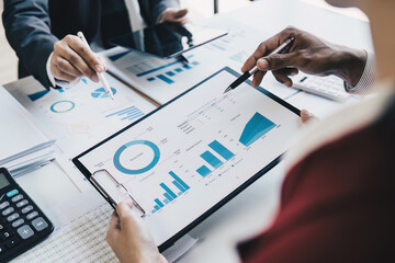 Close up of Diverse colleagues gather brainstorm discuss financial statistics at office meeting. finance, teamwork, Big data Graphs Charts concept