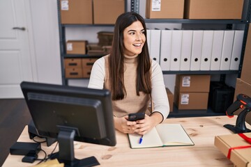 Young beautiful hispanic woman ecommerce business worker using smartphone at office