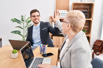 Fototapeta premium Mother and son business workers high five with hands raised up at office