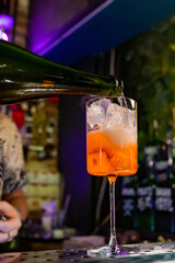 man hand bartender making sweet and sour refreshing Aperol Spritz cocktail on the bar counter