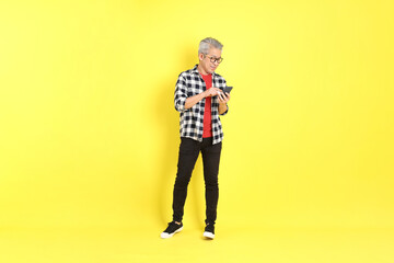 The 40s adult Asian man with casual dressed standing on the yellow background.
