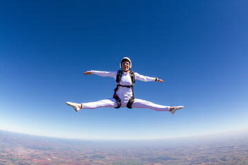 Beautiful woman skydiving in freefall, freestyle position.