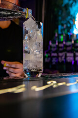 man bartender making cold gin tonic cocktail in bar