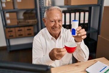 Senior man ecommerce business worker drinking coffee at office