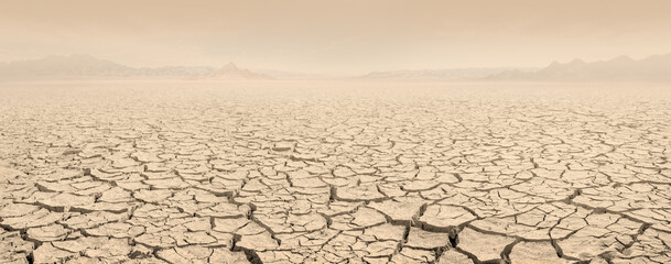 Desertification concept landscape. Dried lakebed panorama with sky filled with clouds of dust