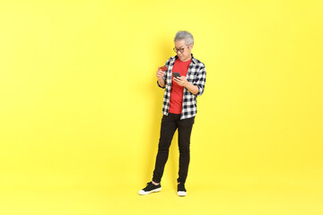 The 40s adult Asian man with casual dressed standing on the yellow background.