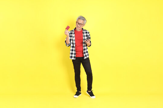 The 40s adult Asian man with casual dressed standing on the yellow background.