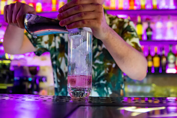 man bartender making cold gin tonic cocktail in bar