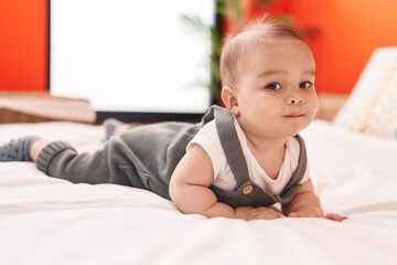 Adorable hispanic toddler smiling confident lying on bed at bedroom