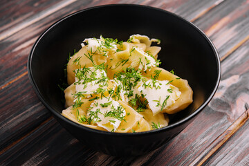 Dumplings filled with mashed potato on black bowl