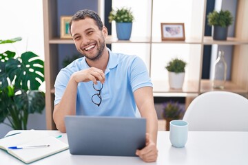 Young man using laptop sitting on table at home